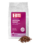 front of Organic Medium Roast coffee bag with pile of roasted beans