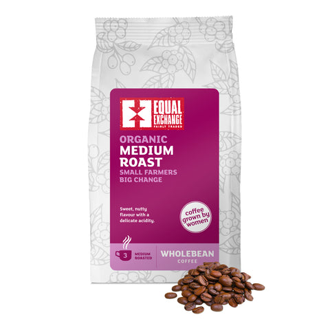 front of Organic Medium Roast coffee bag with pile of roasted beans