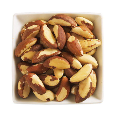 white square bowl filled with whole brazil nuts