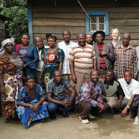 group of Sopacdi cooperative members gathered with Equal Exchange coffee quality manager in front of wooden building